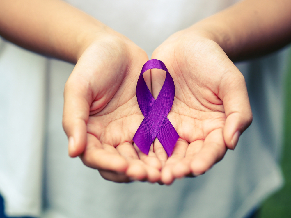 Hands,Holding,Purple,Ribbon,Symbol,Of,Alzheimer,Disease,,Pancreatic,Cancer,